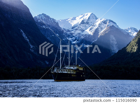 A view of an overnight cruise boat out of Milford Sound at Harrison Cove with the sun shining through the clouds in 2023. 115016090