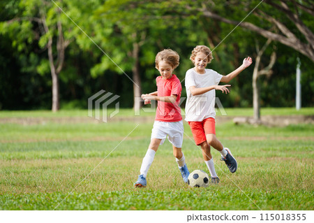 Child playing football. Kids play soccer. 115018355