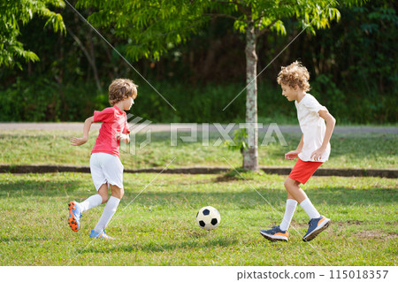 Child playing football. Kids play soccer. 115018357