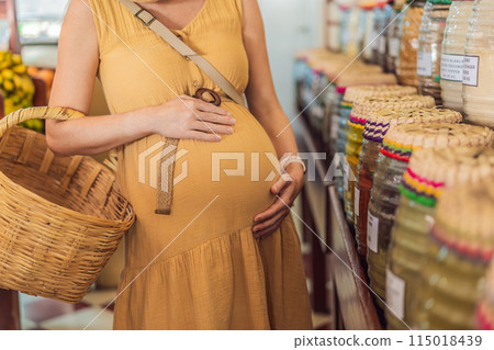 A pregnant woman is at a fruit stand in a grocery store Pregnant woman buying organic vegetables and fruits at Mexican style farmers market 115018439