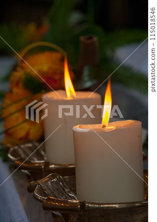 Create a peaceful ambiance with candles and flower decorations for a calming atmosphere 115018546