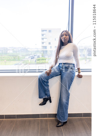 A confident woman in casual chic attire, enjoying a beautiful view from her office window A confident woman in casual chic attire, enjoying a beautiful view from her office window 115018644