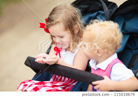 Kids catch a frog. Boy and girl looking at toad. 115018679