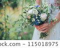 Close up of a woman holding a bouquet wearing a white wedding dress. 115018975