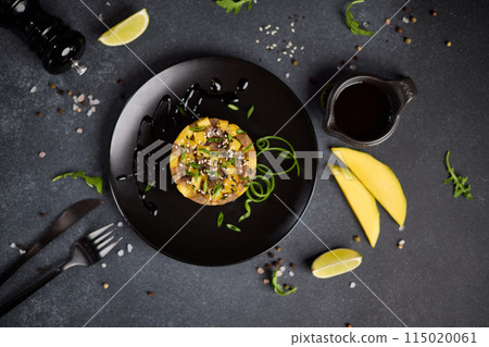 Traditional tuna and mango tartare on black ceramic plate Traditional tuna and mango tartare on black ceramic plate 115020061