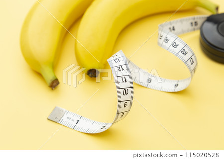 黃色背景上的香蕉和捲尺 115020528