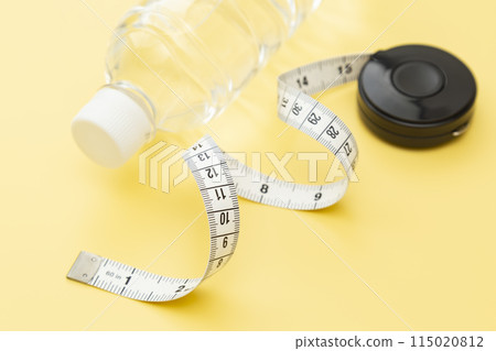 黃色背景的捲尺和飲用水 115020812