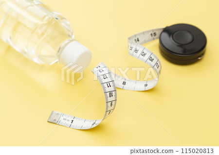 黃色背景的捲尺和飲用水 黃色背景的捲尺和飲用水 115020813