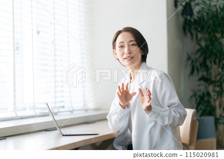 A woman in a white coat examining a patient A woman in a white coat examining a patient 115020981