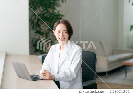 A woman in a white coat examining a patient A woman in a white coat examining a patient 115021291