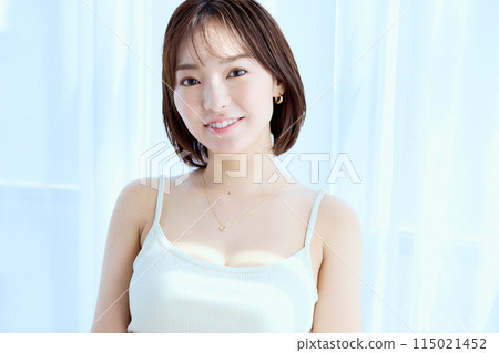 一個女人透過蕾絲窗簾在房間裡放鬆 115021452