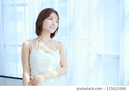 一個女人透過蕾絲窗簾在房間裡放鬆 一個女人透過蕾絲窗簾在房間裡放鬆 115022060