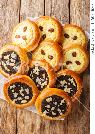 Czech and Slovak Kolach or kolace type of sweet yeast pastry filling with cottage cheese, poppy seeds closeup. Vertical top view Czech and Slovak Kolach or kolace type of sweet yeast pastry filling with cottage cheese, poppy seeds closeup. Vertical top view 115022680
