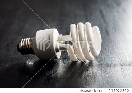 Energy saving light bulb on black table. Fluorescent Lightbulb Energy saving light bulb on black table. Fluorescent Lightbulb 115022820