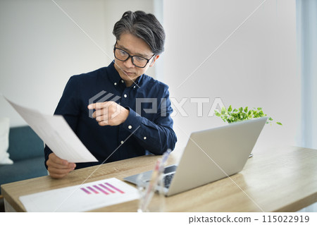 Middle-aged man doing telework in the living room 115022919