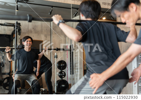 A young man and his trainer do lower body training with squats at the gym (personal training) 115022930