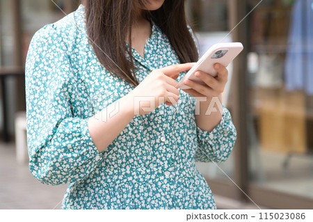 在街角使用智慧型手機的年輕女子 115023086