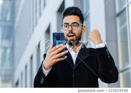 Business man use mobile smartphone celebrating win good message news outdoors in urban city street 115024598
