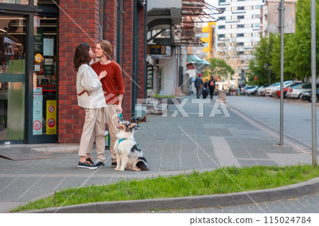 Young couple, man and woman flirting at the street. Family walking together in city with Aussie dog. Copy space 115024784