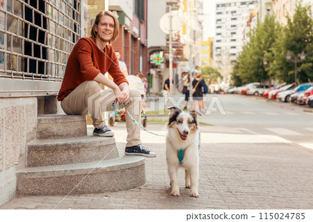Young Caucasian bearded man posing with purebred Aussie dog. Pet training and friendship with dog. Copy space 115024785