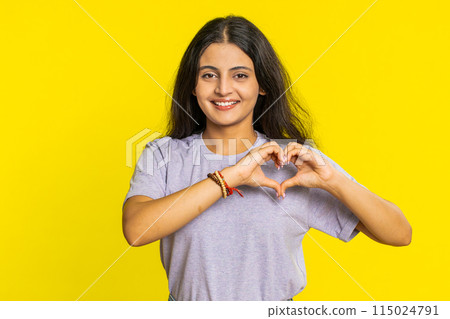 Smiling pretty woman makes heart gesture demonstrates love sign expresses good feelings and sympathy Smiling pretty woman makes heart gesture demonstrates love sign expresses good feelings and sympathy 115024791
