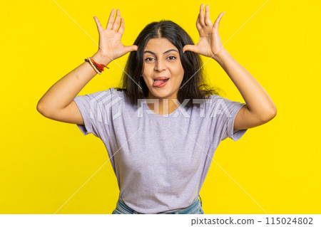 Cheerful funny bully Indian woman showing tongue making silly faces, fooling around, joking, teasing 115024802