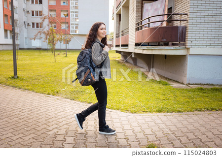 Side view of young happy woman student is walking around city. Concept of freedom and psychology Side view of young happy woman student is walking around city. Concept of freedom and psychology 115024803