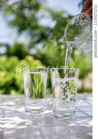 在樹蔭下的桌子上倒水。 115025252