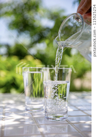 在樹蔭下的桌子上倒水。 115025254