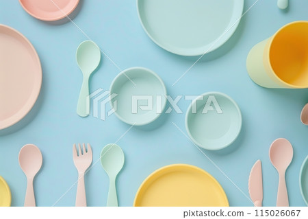Baby feeding accessories, tableware, cutlery set on blue background. First dishware for kids concept. Flat lay, Top View, Copy space. Silicone dishware, cup. Solid color backdrop. Serving baby food 115026067