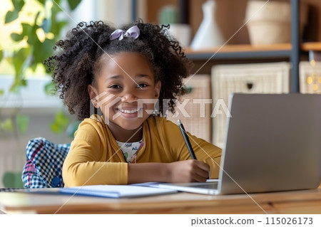 Smart small African girl sit at table with laptop studying at home. 6s child write exercise book prepare homework for school. Little kid handwritten in notebook do task assignment. Learning, education Smart small African girl sit at table with laptop studying at home. 6s child write exercise book prepare homework for school. Little kid handwritten in notebook do task assignment. Learning, education 115026173