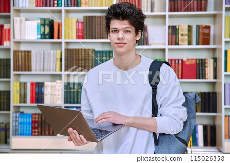 Portrait of handsome young male student with laptop in educational building in library Portrait of handsome young male student with laptop in educational building in library 115026358