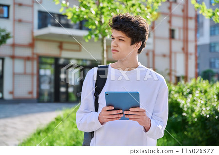 Young guy college student using digital tablet outdoor Young guy college student using digital tablet outdoor 115026377