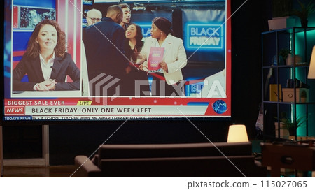 Empty apartment built as home theatre with ultrawide smart TV showing news broadcast about black friday sales frenzy. VOD channel showing newscaster talking about store bargains reportage 115027065