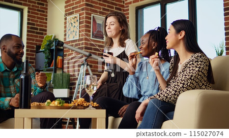 BIPOC coworkers celebrating business success at work, gathered at home to toast for their accomplishments. Cheerful colleagues throwing apartment party, drinking wine glasses 115027074
