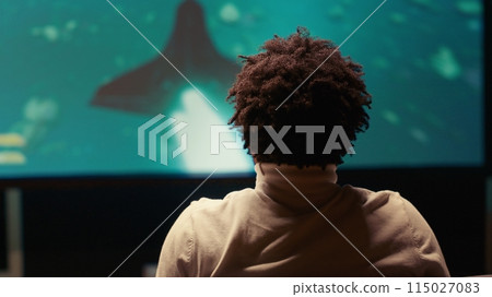 Man plays spaceship science fiction singleplayer game with overlay HUD showing health, fuel, ammo bars. Gamer flying in spacecraft shooting laser beams at asteroids, high quality ray tracing graphics Man plays spaceship science fiction singleplayer game with overlay HUD showing health, fuel, ammo bars. Gamer flying in spacecraft shooting laser beams at asteroids, high quality ray tracing graphics 115027083