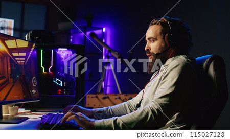 Man playing science fiction FPS videogame with friends, having fun in dark apartment room. Gamer competing in PvP online multiplayer game, talking with internet players through headphones mic Man playing science fiction FPS videogame with friends, having fun in dark apartment room. Gamer competing in PvP online multiplayer game, talking with internet players through headphones mic 115027128