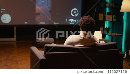 Man playing shooter videogame on TV with gun shooting laser bullets at flying robots in dark atmospheric industrial setting. Gamer enjoying competitive PvP fps internet multiplayer tournament game Man playing shooter videogame on TV with gun shooting laser bullets at flying robots in dark atmospheric industrial setting. Gamer enjoying competitive PvP fps internet multiplayer tournament game 115027156