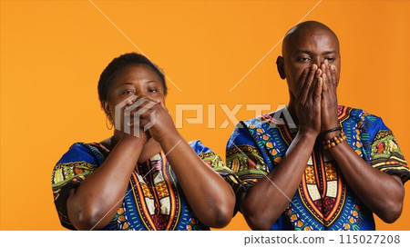 Ethnic couple doing three wise monkeys symbol on camera, showcasing sign to not hear, see or speak in studio. African american man and woman covering their eyes, mouth and ears. Ethnic couple doing three wise monkeys symbol on camera, showcasing sign to not hear, see or speak in studio. African american man and woman covering their eyes, mouth and ears. 115027208