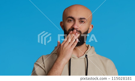 Lovely sweet person blowing air kisses on camera, dping romantic gesture and being flirty over blue background. Middle eastern guy sending a kiss to express his honest feelings. Camera 2. Lovely sweet person blowing air kisses on camera, dping romantic gesture and being flirty over blue background. Middle eastern guy sending a kiss to express his honest feelings. Camera 2. 115028181
