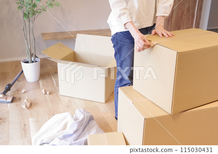 A woman packing up a cardboard box 115030431