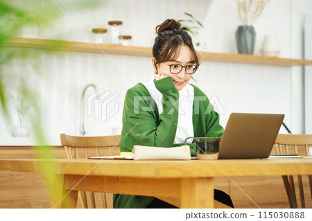 一個女人在客廳裡看電腦 115030888