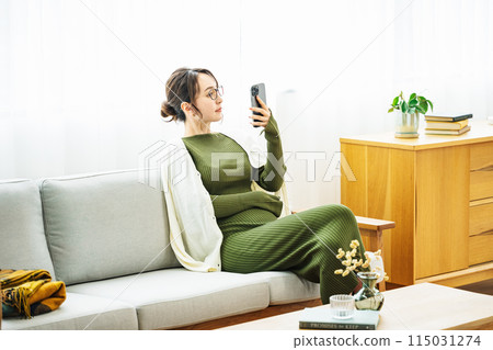 在家沙發上看智慧型手機的女人 115031274