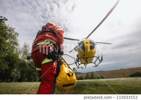 Paramedic running to helicopter of emergency medical service. 115033552