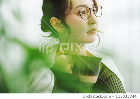 A woman drinking coffee at home A woman drinking coffee at home 115033744