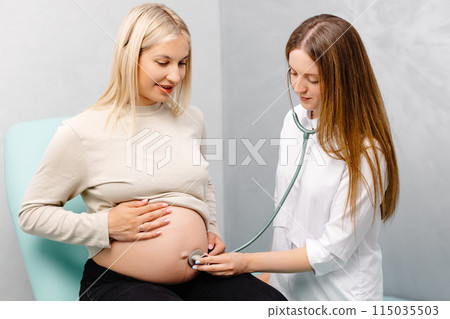 Female doctor using stethoscope examining pregnant woman in clinic. Medical exam pregnant woman Female doctor using stethoscope examining pregnant woman in clinic. Medical exam pregnant woman 115035503