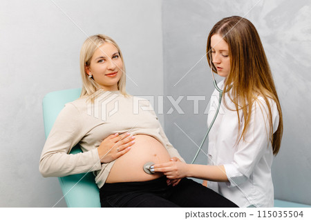 Female doctor using stethoscope examining pregnant woman in clinic. Medical exam pregnant woman Female doctor using stethoscope examining pregnant woman in clinic. Medical exam pregnant woman 115035504