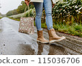 Happy woman carrying colorful shopping bags while walking on the bustling city street 115036706