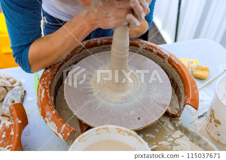 Working with wet soft clay on potters wheel, potter creates bowl Working with wet soft clay on potters wheel, potter creates bowl 115037671