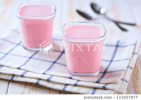 homemade fruit pink yogurt in a glass jars on a white table, selective focus. homemade fruit pink yogurt in a glass jars on a white table, selective focus. 115037977